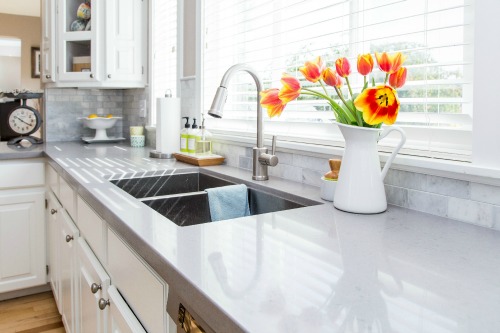 A modern kitchen featuring white cabinets and a sleek sink, creating a bright and inviting atmosphere.